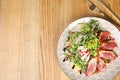 Delicious salad with roasted duck breast served on table, flat lay. Space for text Royalty Free Stock Photo