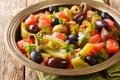 Delicious salad of tomatoes and green peppers Chlada felfel with anchovies and olives close-up in a bowl. horizontal Royalty Free Stock Photo