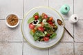 Delicious salad with vegetables, spinach and olives served on light table, flat lay