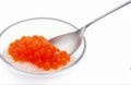 Delicious salmon caviar heaped on a spoon, cut out isolated on white background