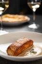Delicious salmon filet with two sauce on a white plate serving with wine in restaurant. Healthy seafood meal Royalty Free Stock Photo