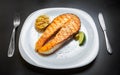 Delicious salmon steak grilled in seafood restaurant for dinner.Gourmet red trout fish cooked on grill,served on white ceramic Royalty Free Stock Photo