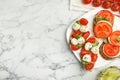 Delicious sandwiches with mozzarella, fresh tomatoes and basil on white marble table, flat lay. Space for text