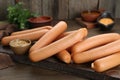 Delicious sausages and mustard on wooden table