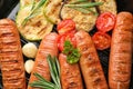 Delicious sausages with vegetables on pan, closeup. Barbecue food