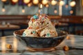 Delicious Scoops of Vanilla Ice Cream with Colorful Sprinkles in a Dark Bowl on a Wooden Table with Blurred Restaurant Background Royalty Free Stock Photo