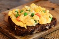 Scrambled eggs with vegetables on rye bread. Soft scrambled egg omelette. Homemade cuisine. Rustic stile. Closeup Royalty Free Stock Photo