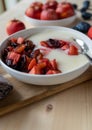 Semolina porridge with fresh cooked plums and apples on a plate. Lactose free