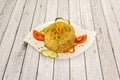 Delicious serving of biryani rice with vegetables, tomatoes and cucumbers