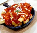 A delicious serving of French Fries served with spicy chili sauce and a dash of mayonnaise.