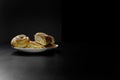 Delicious sesame buns or pies on white plate standing on black wooden table background Royalty Free Stock Photo