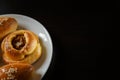 Delicious sesame buns or pies on white plate standing on black wooden table background Royalty Free Stock Photo