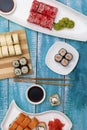 Delicious set of Nigiri sushi served with traditional soy sauce and chopsticks, flat lay on blue wooden background. Tasty Japanese Royalty Free Stock Photo