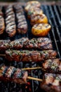 Delicious shashlik skewers with meat and vegetables on a charcoal grill outdoors