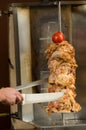 Delicious slabs of skewered fast food shawarma chicken and lamb meat turn side by side on a spit