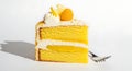 Delicious slice of layered yellow cake with frosting and fruit garnish served with a fork Royalty Free Stock Photo