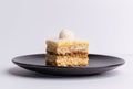 Delicious slice of Plazma cake on a matte dark grey plate on a white background