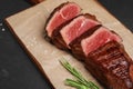 Delicious sliced beef tenderloin on black table, closeup