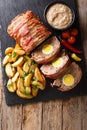 Delicious sliced meat loaf wrapped in bacon with potato wedges a