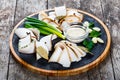 Delicious sliced pork fat with spices, green onions, garlic and sauce on cutting board on wooden background Royalty Free Stock Photo