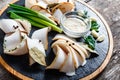 Delicious sliced pork fat with spices, green onions, garlic and sauce on cutting board on wooden background close up Royalty Free Stock Photo