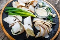 Delicious sliced pork fat with spices, green onions, garlic and sauce on cutting board on wooden background close up Royalty Free Stock Photo