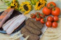 Delicious slices of bacon, rye black bread, ripe red tomatoes on sackcloth, old sunflowers Top view. Fresh organic Food Royalty Free Stock Photo