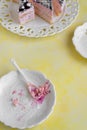 Delicious slices of cake with strawberry cream and coconut, yellow background, creamy dessert