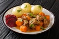 Delicious slow stewed beef kalops with boiled potatoes and pickled beets close-up in a plate. horizontal