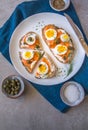 Delicious smoked salmon sourdough toast with goat cream cheese and cut boiled egg, garnished with dill, chives & pickled Capers Royalty Free Stock Photo