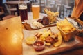 Delicious smoked sausage with chips, french fries and steak with Royalty Free Stock Photo