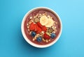 Delicious smoothie bowl with fresh berries, banana and granola on light blue background, top view Royalty Free Stock Photo