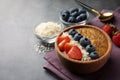 Delicious smoothie bowl with fresh berries, chia seeds and coconut flakes on grey table, closeup. Space for text Royalty Free Stock Photo