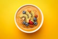 Delicious smoothie bowl with fresh berries, kiwi and nuts on orange background, top view Royalty Free Stock Photo