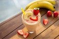 Delicious smoothie garnished with strawberries and banana in glass. Generative Ai