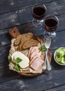 Delicious snack to wine. Smoked ham, cheese and two glasses with red wine