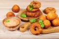 Delicious snacks: cheese balls and onion rings with sauce