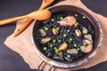 Delicious soup from black homemade noodles made of cuttlefish ink with mussels, shrimps and green peas. Italian cuisine