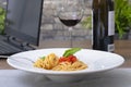 Delicious spaghetti dish with wine and laptop Royalty Free Stock Photo