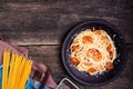 Delicious spaghetti pasta with prawns and cheese served in a black bowl on a black background table Italian recipe, tomato sauce, Royalty Free Stock Photo