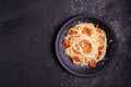 Delicious spaghetti pasta with prawns and cheese served in a black bowl on black background. Italian food noodles, tomato sauce, Royalty Free Stock Photo