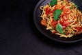 Delicious spaghetti pasta with prawns and cheese served on a black plate on a black background table Italian recipe, tomato sauce Royalty Free Stock Photo