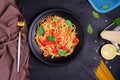 Delicious spaghetti pasta with prawns and cheese served on a black plate. With vegetables, Italian tomato sauce, and spices Royalty Free Stock Photo