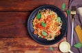 Delicious spaghetti pasta with prawns and cheese served on a black plate on a wooden table Italian recipe tomato sauce vegetables Royalty Free Stock Photo