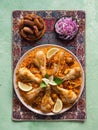 Delicious spicy chicken Biryani in white bowl on black background, Indian or Pakistani food.