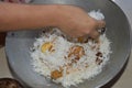 Delicious spicy homemade chicken biryani making in bowl by an indian woman