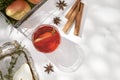 Delicious spicy hot mulled red wine with cinnamon, star anise and slice pear served in a carafe and glass for a cold winter