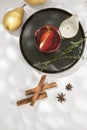 Delicious spicy hot mulled red wine with cinnamon, star anise and slice pear served in a carafe and glass for a cold winter