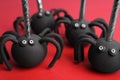 Delicious spider shaped cake pops on red background. Halloween treat