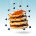 Delicious stack of pancakes with blueberries and syrup falling in slow motion Royalty Free Stock Photo